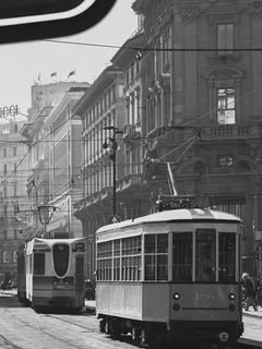 Černobílá fotografie dvou tramvajových vozů ve městě