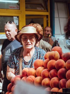 Žena v hnědém klobouku s červeným jablkem v rukou