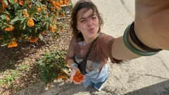 Žena fotí selfie s oranžovými květy na zahradě za slunečného dne