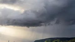 Paprsak světla na zelené trávě pod bílými mraky