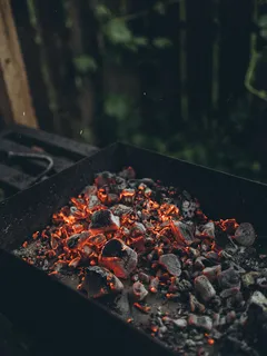 Ohniště plné uhlí a kamenů pro grilování a táboření